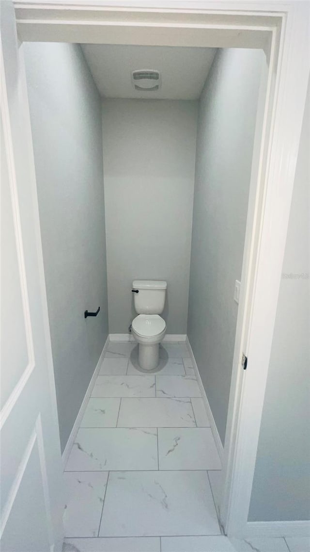 bathroom featuring tile flooring and toilet