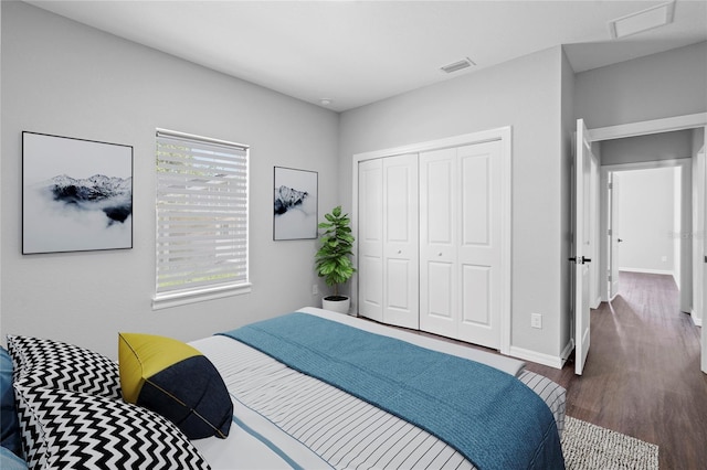 bedroom featuring multiple windows, a closet, and dark wood-type flooring