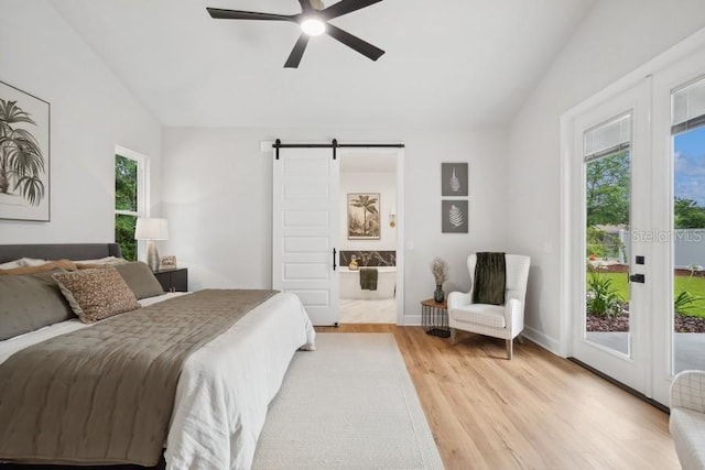 bedroom featuring lofted ceiling, access to exterior, connected bathroom, ceiling fan, and a barn door