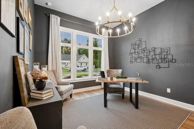 office area with a healthy amount of sunlight, hardwood / wood-style floors, and an inviting chandelier