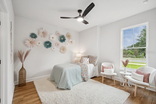 bedroom featuring multiple windows, ceiling fan, and hardwood / wood-style floors