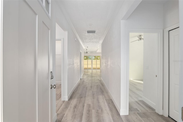 corridor featuring ornamental molding and light wood-type flooring