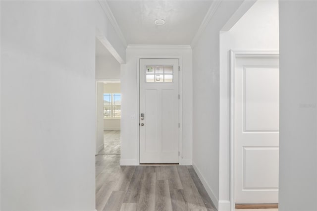 foyer with light wood-type flooring and crown molding