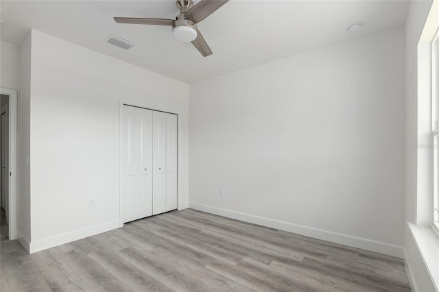 unfurnished bedroom featuring ceiling fan, a closet, and light hardwood / wood-style flooring