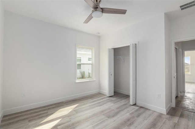 unfurnished bedroom featuring a closet, light hardwood / wood-style floors, and ceiling fan