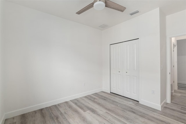 unfurnished bedroom with light hardwood / wood-style floors, a closet, and ceiling fan