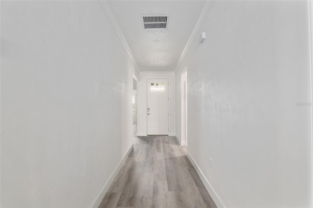 hallway featuring ornamental molding and light wood-type flooring