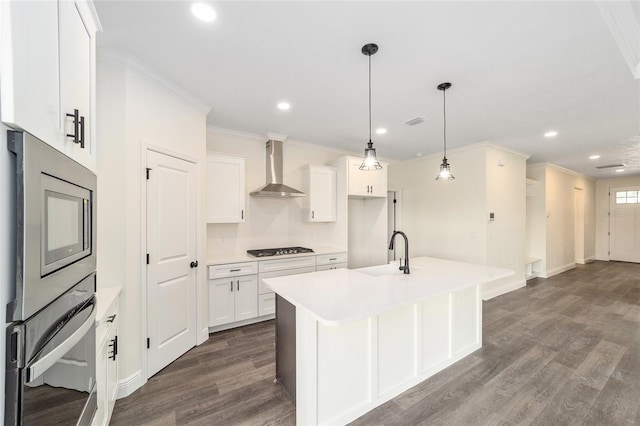 kitchen featuring white cabinetry, decorative light fixtures, gas stovetop, dark wood-type flooring, and wall chimney range hood