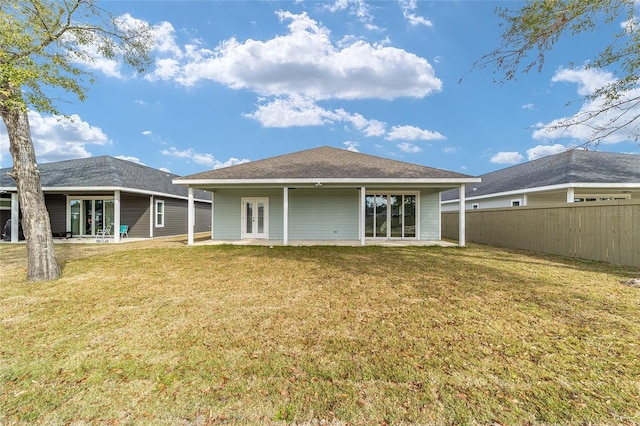 rear view of property featuring a lawn and a patio area