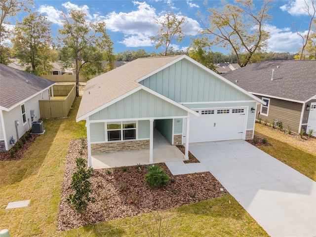 craftsman-style house with a front yard, a garage, and central AC unit