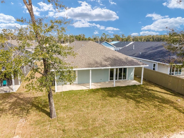 rear view of house featuring a lawn and a patio