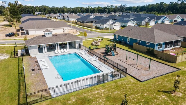 view of swimming pool featuring a yard, a playground, and a patio area