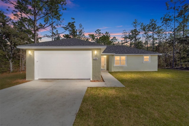 ranch-style house with a garage and a lawn