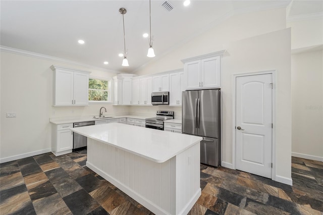 kitchen featuring white cabinets, a center island, appliances with stainless steel finishes, dark tile patterned flooring, and vaulted ceiling