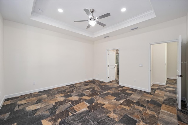 spare room featuring ceiling fan, a raised ceiling, and dark tile patterned floors