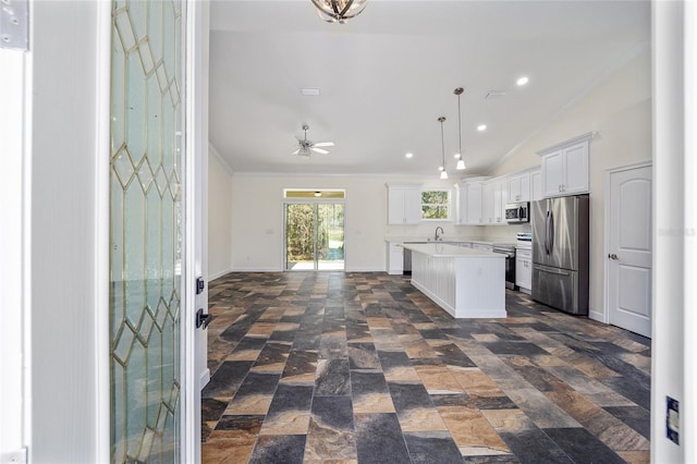 kitchen with decorative light fixtures, stainless steel appliances, dark tile patterned floors, vaulted ceiling, and a kitchen island