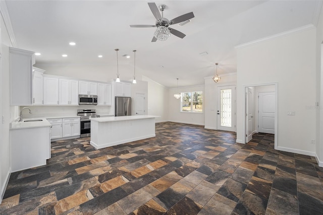 kitchen with appliances with stainless steel finishes, sink, hanging light fixtures, a center island, and white cabinetry