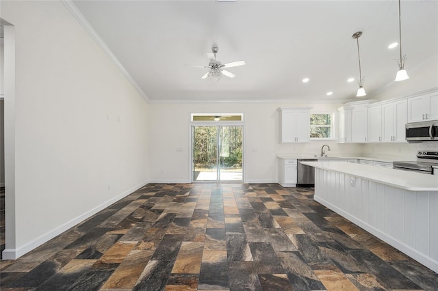 kitchen with stainless steel appliances, sink, ornamental molding, a healthy amount of sunlight, and white cabinets