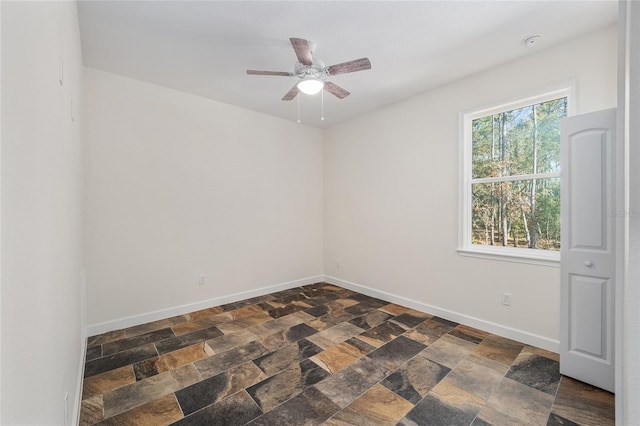 tiled spare room with ceiling fan