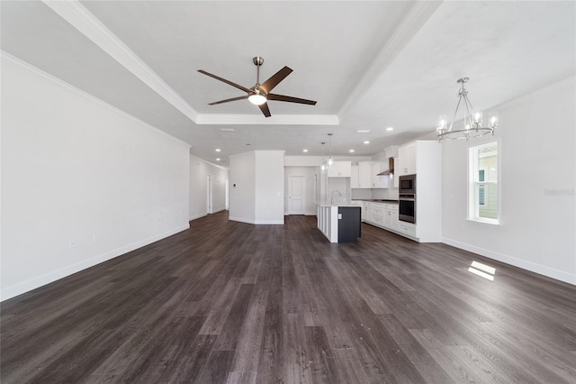 unfurnished living room with dark wood-type flooring, a raised ceiling, and sink