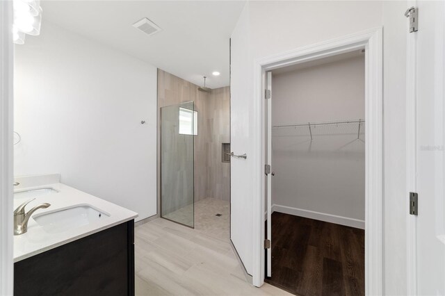 bathroom with dual vanity, hardwood / wood-style floors, and an enclosed shower