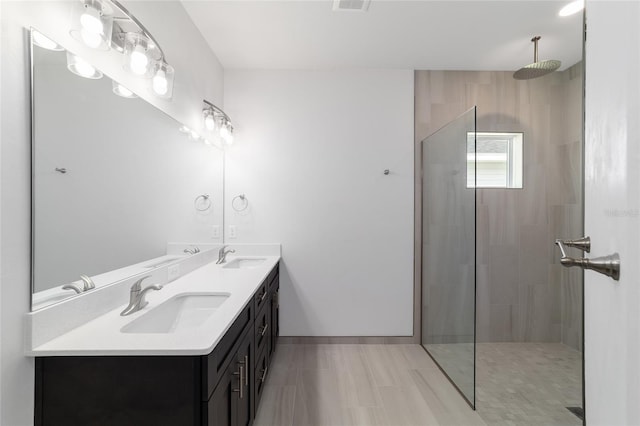 bathroom featuring dual vanity, a shower with shower door, and tile patterned flooring