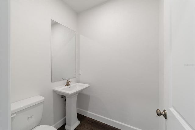 bathroom with toilet and hardwood / wood-style floors