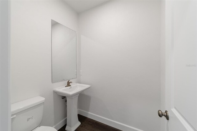 bathroom with hardwood / wood-style floors and toilet