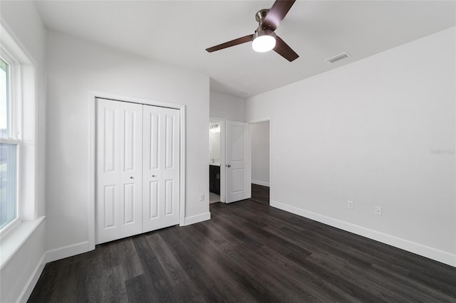 unfurnished bedroom with dark wood-type flooring, ceiling fan, and a closet