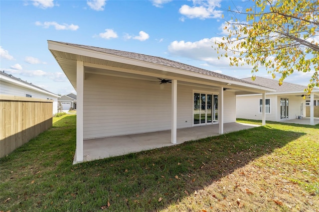 rear view of property with a patio area, a yard, and ceiling fan