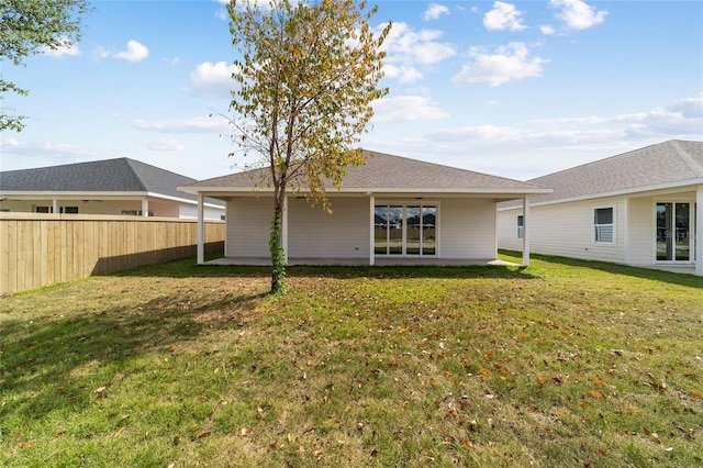 rear view of property featuring a yard