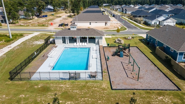 view of swimming pool featuring a playground, a yard, and a patio area