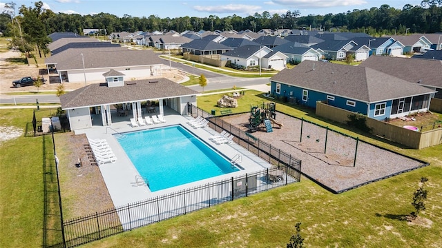 view of swimming pool with a playground, a yard, and a patio area