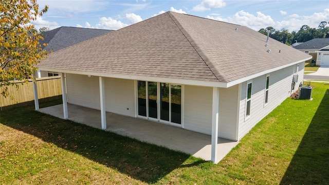 rear view of property with a lawn, a patio, and central air condition unit