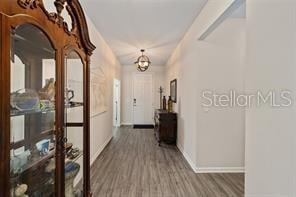 hall featuring an inviting chandelier and dark wood-type flooring