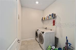 clothes washing area with light colored carpet and separate washer and dryer