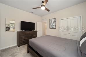 bedroom with light colored carpet, a closet, and ceiling fan