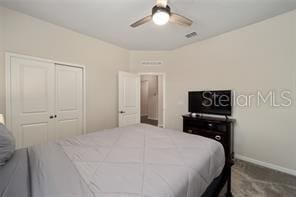 bedroom with dark carpet, a closet, and ceiling fan