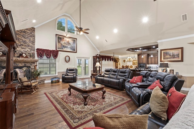 living room with plenty of natural light, high vaulted ceiling, dark hardwood / wood-style floors, and ceiling fan with notable chandelier