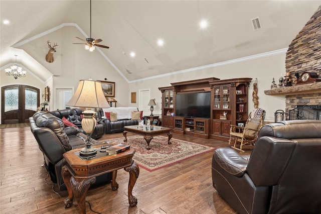 living room with french doors, ornamental molding, dark hardwood / wood-style flooring, a fireplace, and ceiling fan with notable chandelier