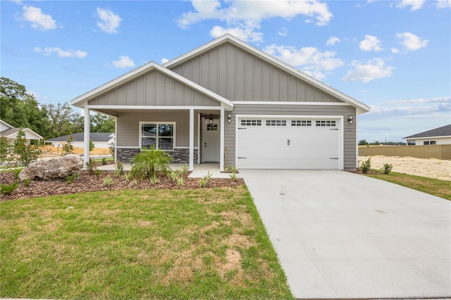 craftsman house with a garage, a front lawn, and covered porch