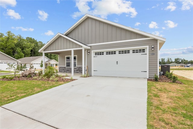 craftsman inspired home with a garage, a front lawn, and covered porch