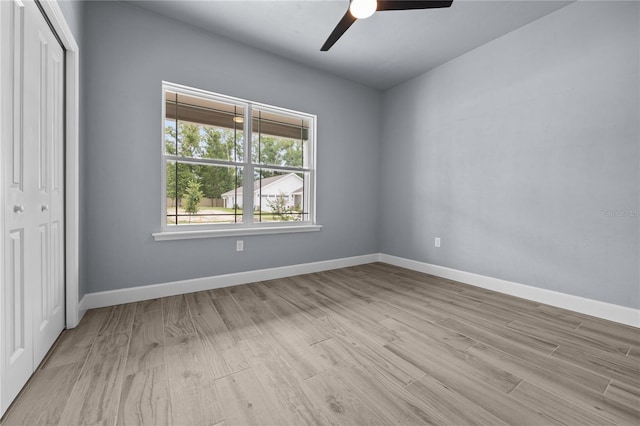 unfurnished bedroom with a closet, light wood-type flooring, and ceiling fan