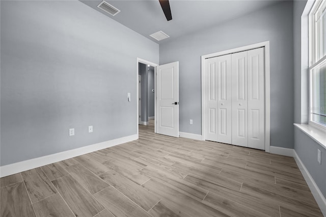 6624 SW 10th Ln, Gainesville, FL 32607 - unfurnished bedroom with a closet, light wood-style floors, a ceiling fan, and baseboards