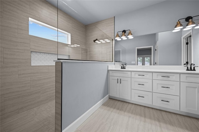 bathroom featuring a tile shower, a wealth of natural light, and vanity