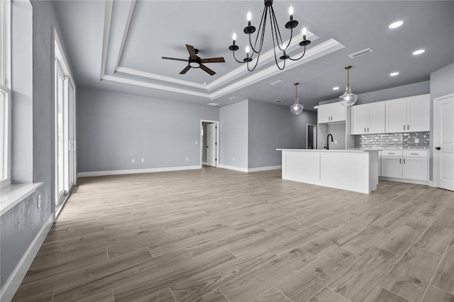 6624 SW 10th Ln, Gainesville, FL 32607 - unfurnished living room with a raised ceiling, ceiling fan, a sink, baseboards, and recessed lighting