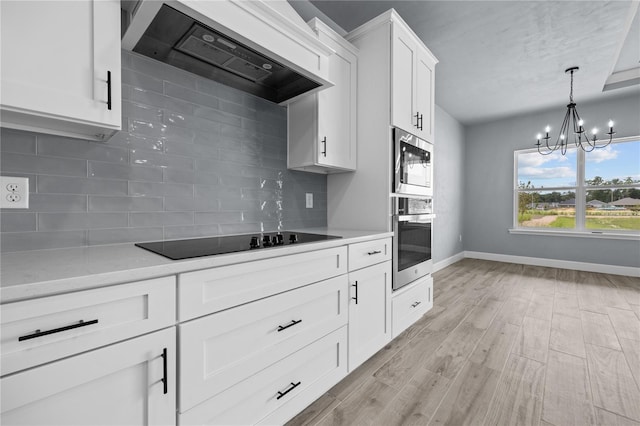 6624 SW 10th Ln, Gainesville, FL 32607 - kitchen with stainless steel appliances, wall chimney range hood, light countertops, and baseboards