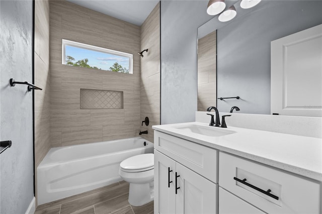 full bathroom with vanity, tiled shower / bath combo, and toilet