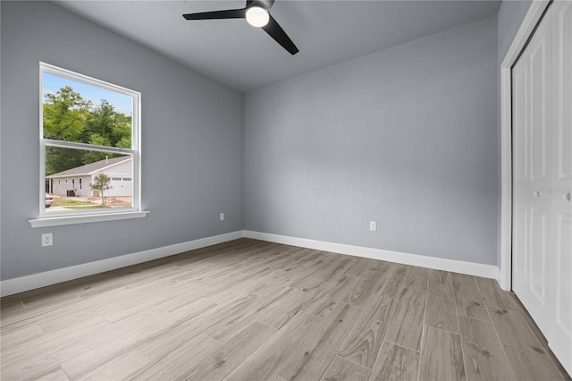 unfurnished bedroom featuring ceiling fan, light wood-type flooring, and a closet