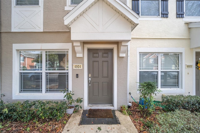 property entrance with stucco siding